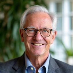 Smiling portrait of Robert L., 51, looking alert and focused, perhaps gardening or engaged in a creative hobby.